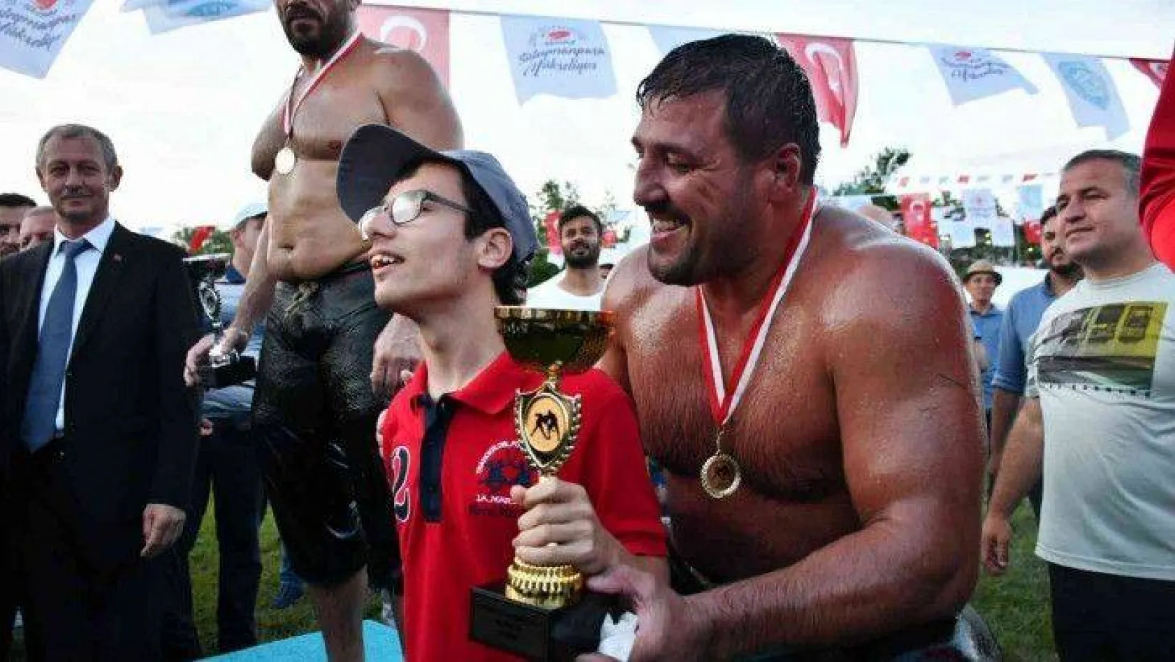 Yağlı güreşlerin şampiyonu, kupasını engelli gence hediye etti