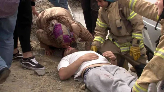 Yerde yatan yaralı oğlunu alnından öperek sakinleştirdi