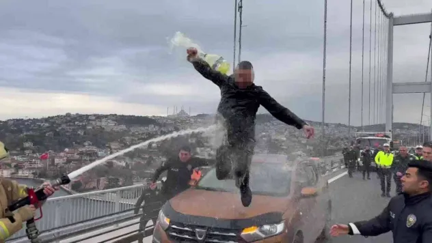 Otomobilin üzerine çıkıp benzin döken şahsa itfaiyeciden 'su sıkma' müdahalesi
