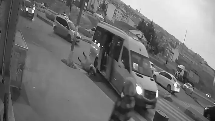 Kapısı açık minibüs ters yönden dönerken kucağında çocukla yola düşen kadın kamerada